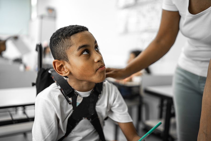 Female teacher helping student with disability in the classroom