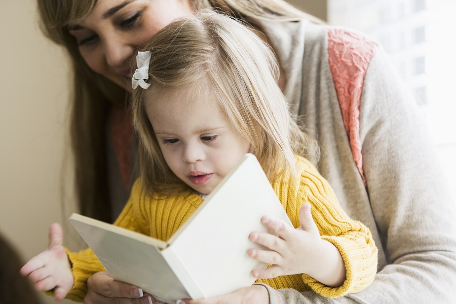 Mother reading to daughter with down syndrome