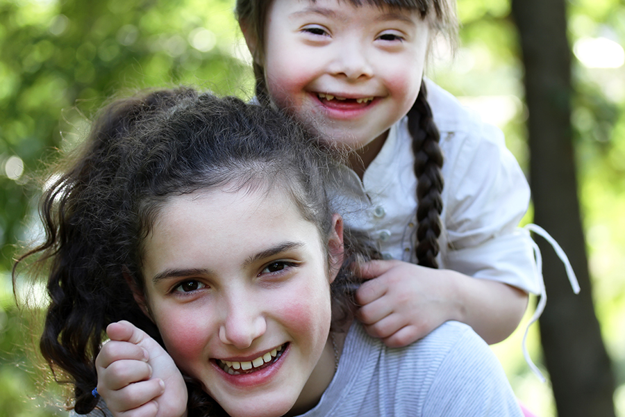 Happy sisters playing together outside