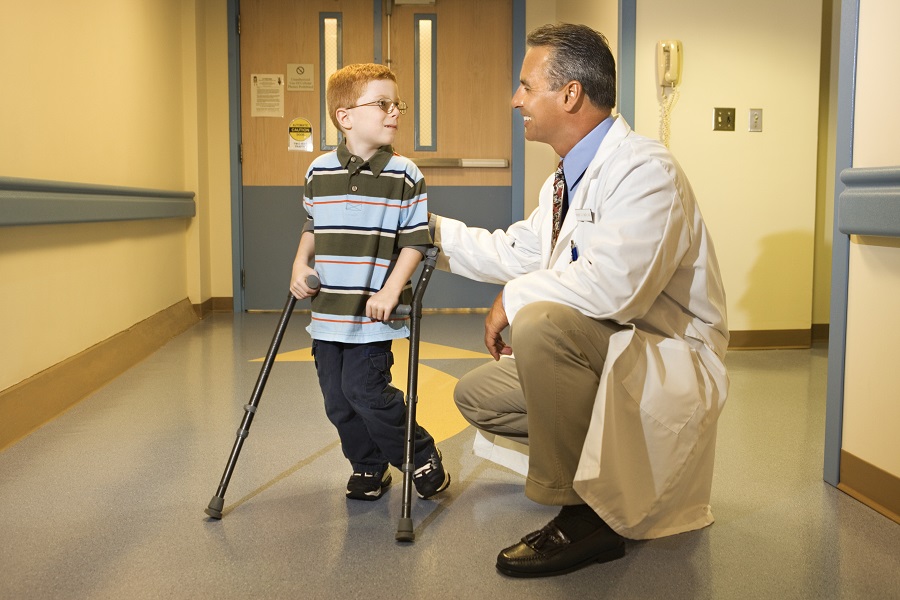 Doctor with boy on crutches